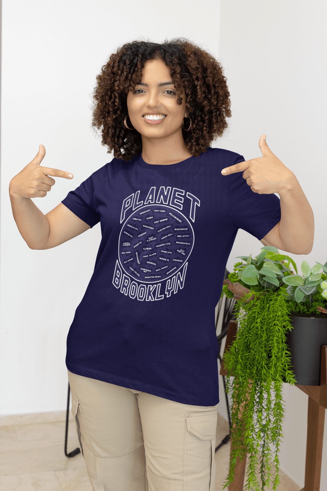 Planet-Brooklyn-Navy-blue-SS-shirt-woman-pointing-at-her-shirt.png Planet Brooklyn Short Sleeve - Image 1