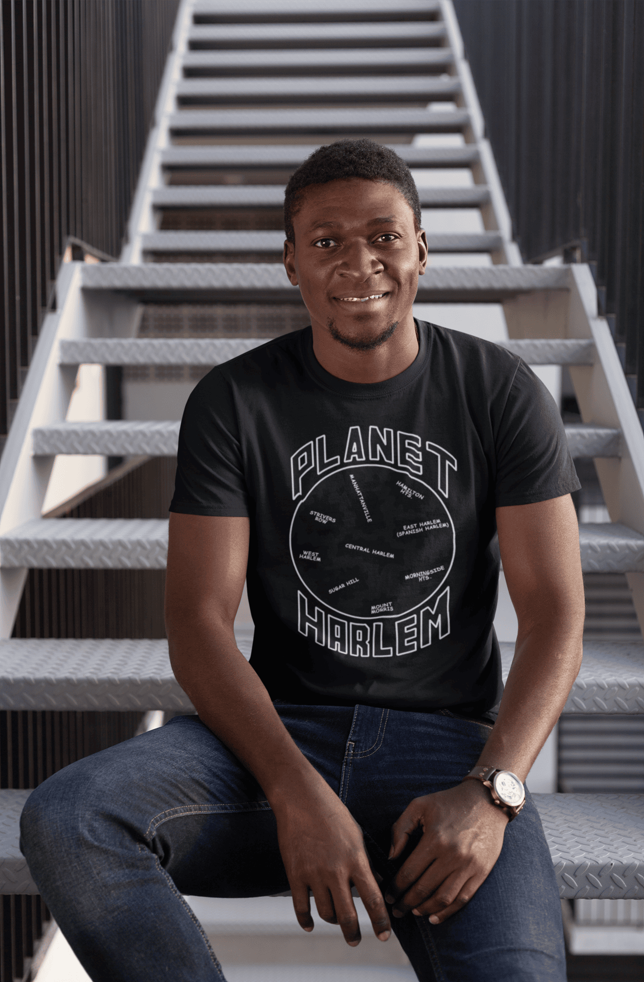Planet-Harlem-Black-SS-shirt-man-sitting-on-a-stairway.png Planet Harlem Short Sleeve - Image 1